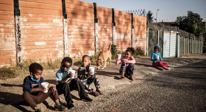 Children in South Africa eat porridge distributed by the non profit organisation and charity group -Hunger has no Religion CREDIT: MARCO LONGARI/AFP